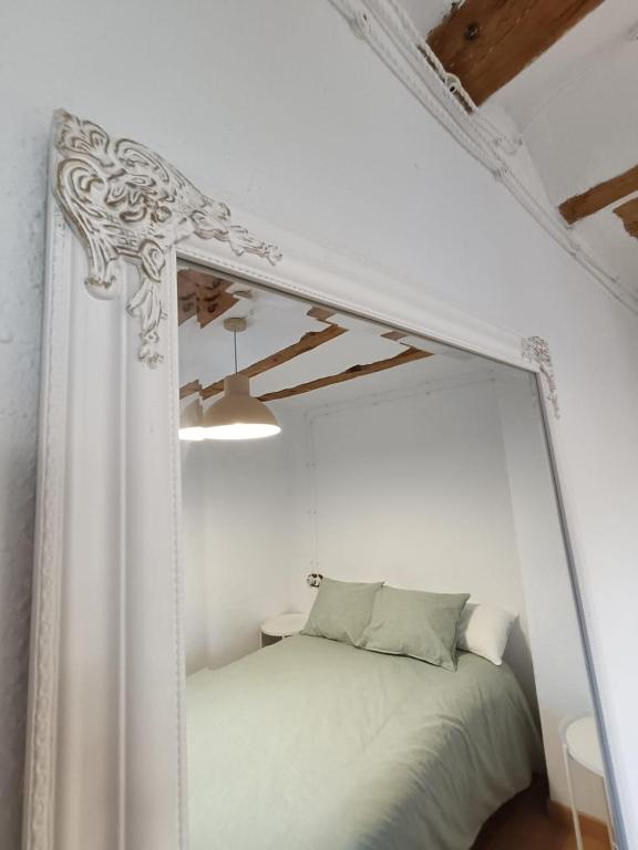a white bed in a white room with a mirror at Casa Remedios in Cubla
