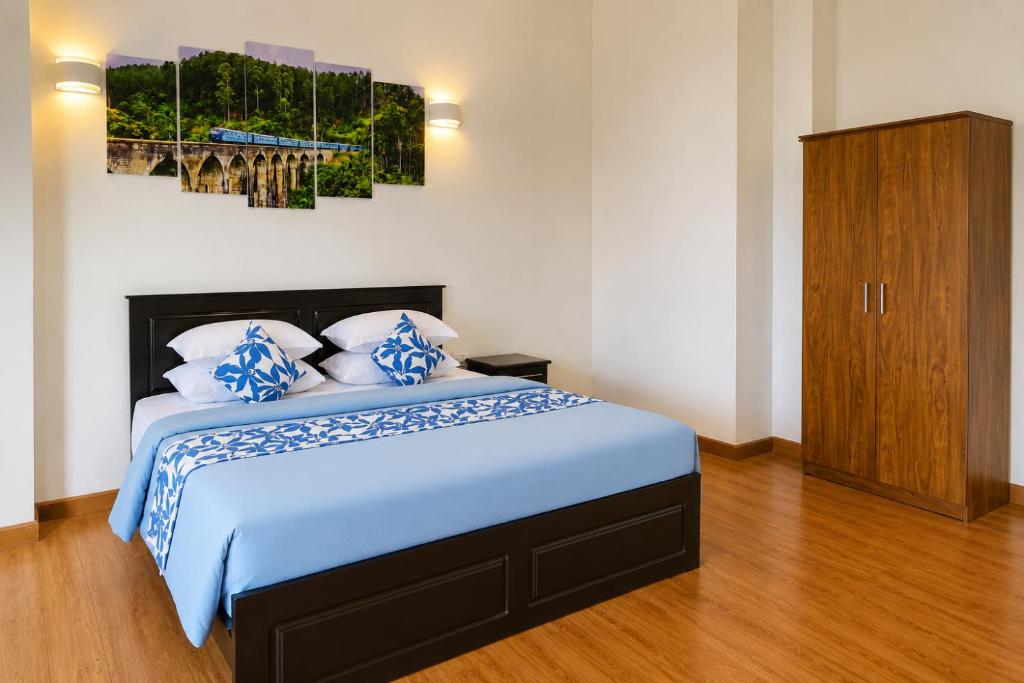 a bedroom with a bed with blue and white pillows at Bundala Forest Resort Yala in Weerawila