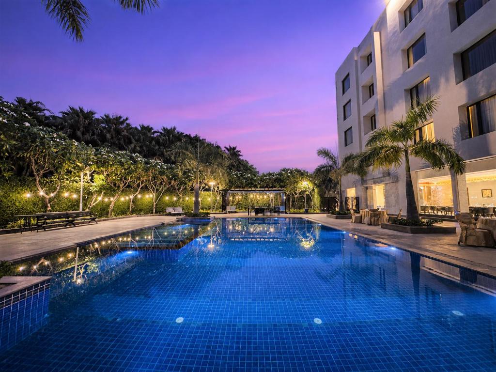 a swimming pool in front of a building at night at Hillcrest Hotel & Resort, Abu Road in Ābu Road