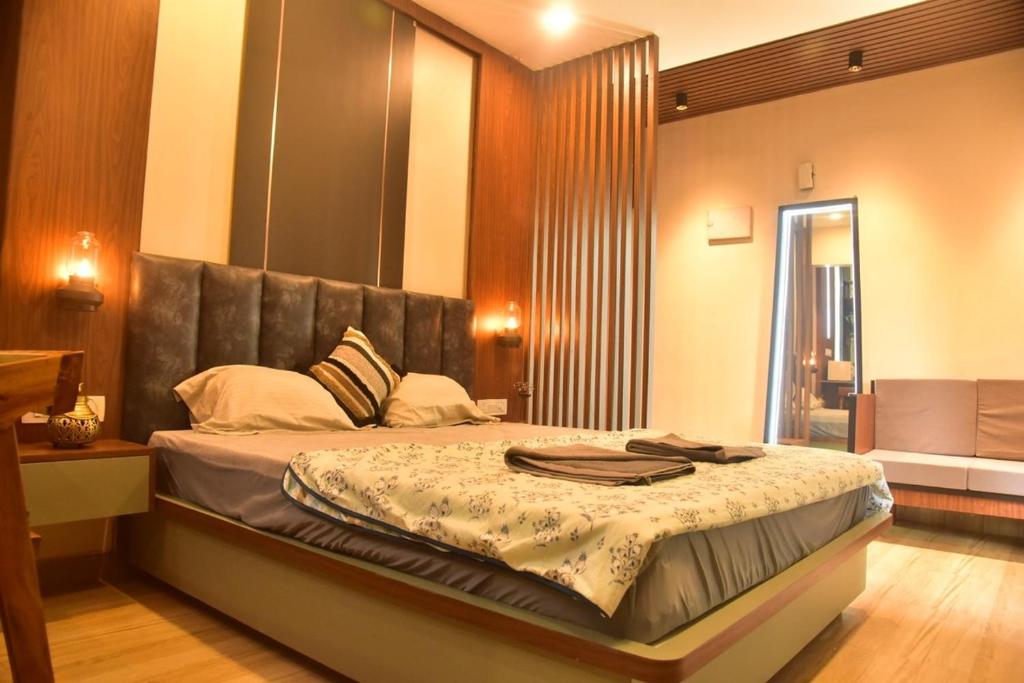 a bedroom with a large bed with a leather headboard at UnigoOne Apartments, BH, Palolem in Canacona