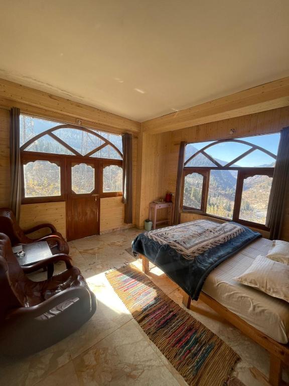 a bedroom with a bed and large windows at Infinity Snowline , Kalga in Kalgha