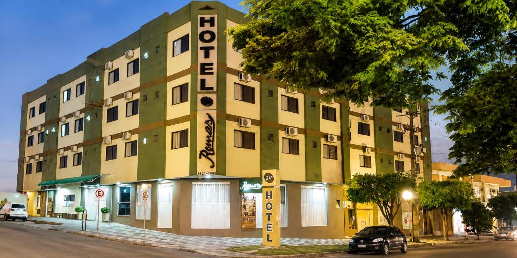 a building with a sign on the side of it at Romas Hotel in Umuarama