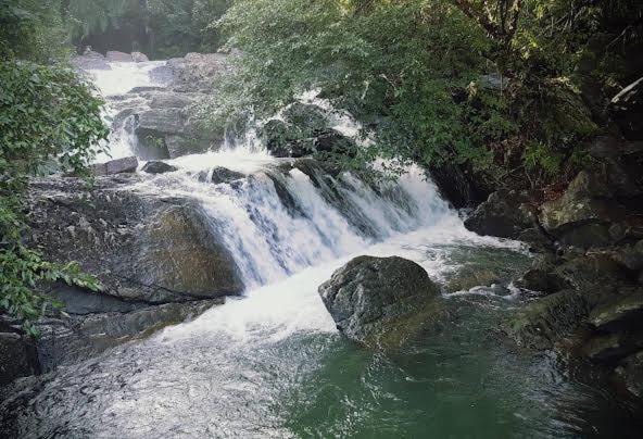 a waterfall in the middle of a river at Cottage by Ranmuduella in Labugama