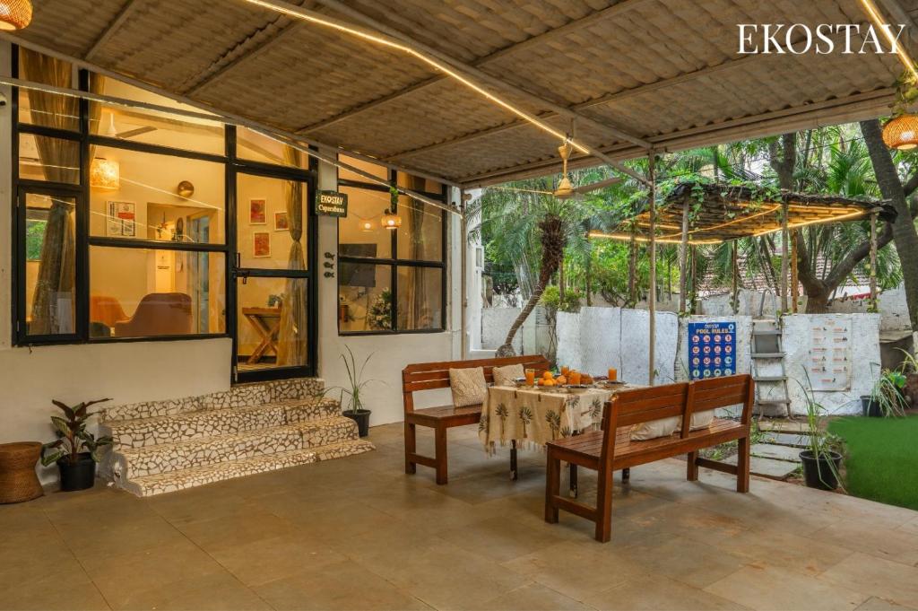 a patio with a table and some chairs and a table at EKOSTAY - Copacabana Villa in North goa
