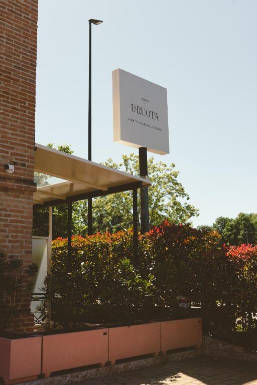 a sign for a library with flowers in front of a building at La Ruota Rooms in Casalgrande