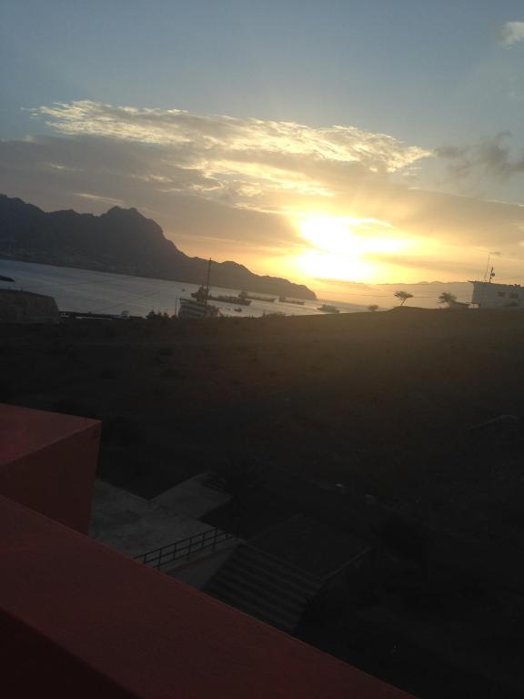 a sunset over a body of water with the sun setting at Residencial Beleza in Mindelo