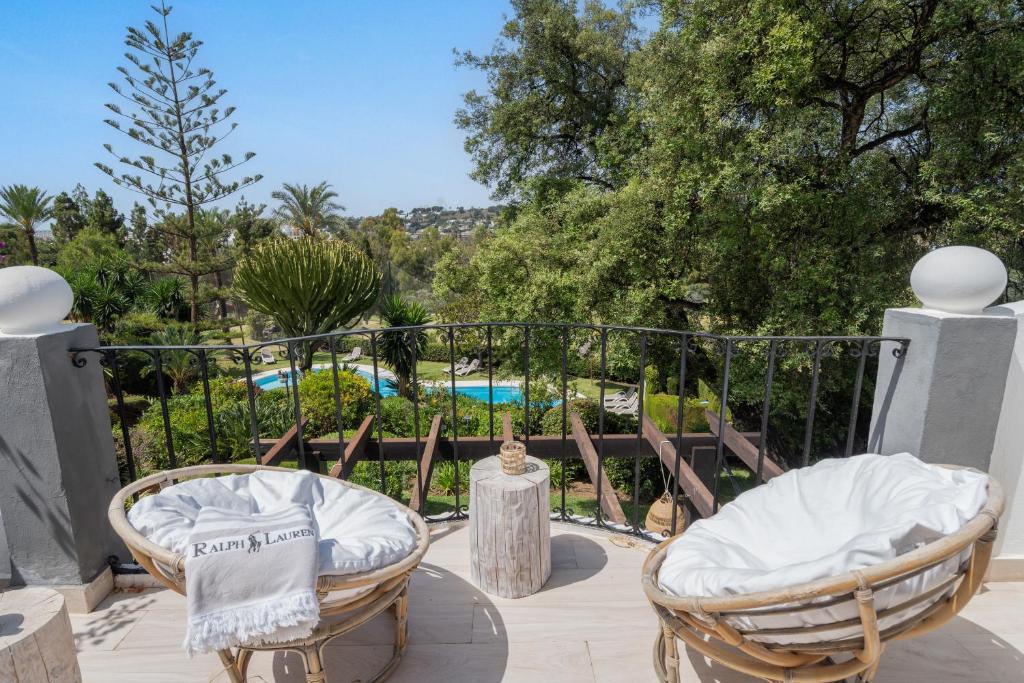 a patio with two chairs and a view of a pool at Las Pergolas in Marbella