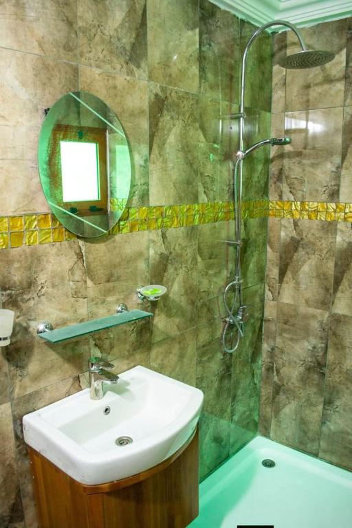 a bathroom with a sink and a shower at Hôtel LEWI 1 Bouaké in Bouaké
