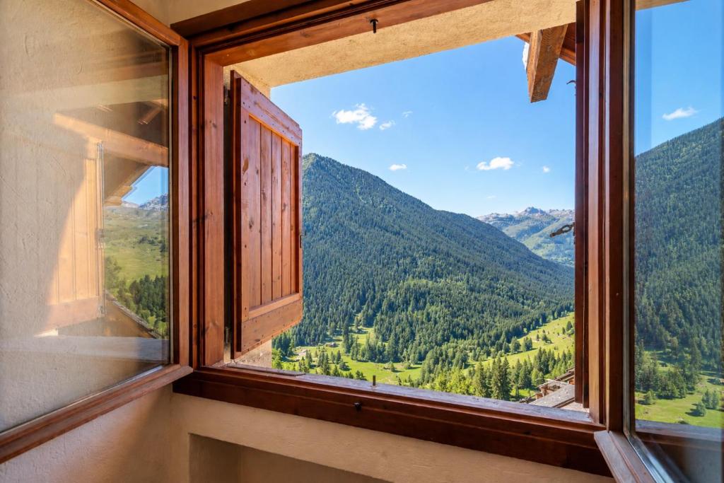 an open window with a view of mountains at Hostdomus-La casa di Luna in Grange Sises