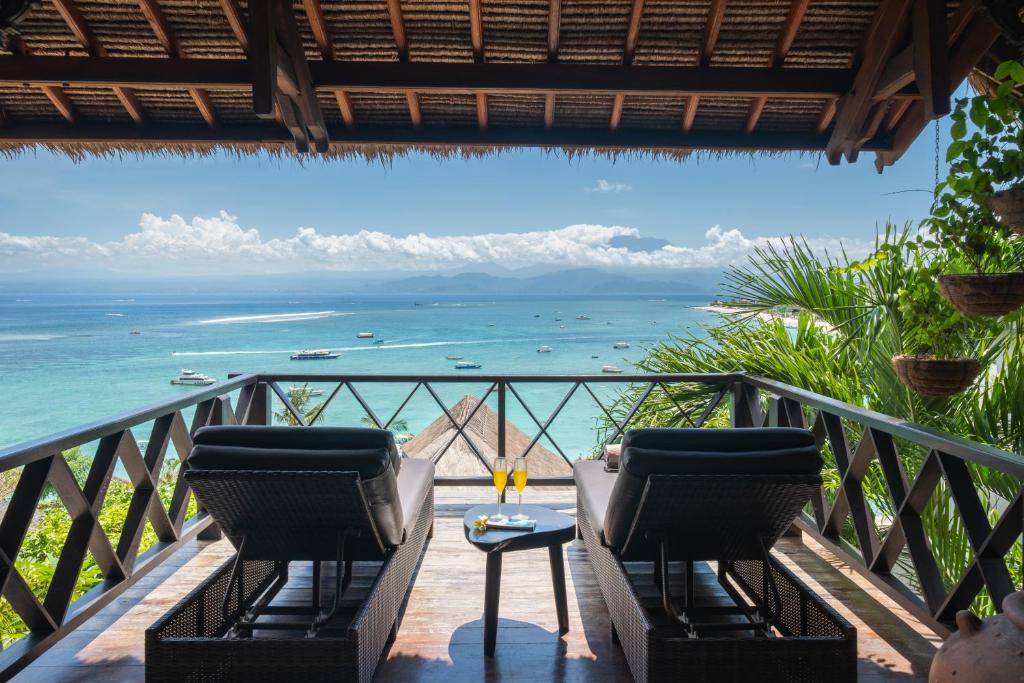 a balcony with chairs and a view of the ocean at Villa Atas Lembongan in Nusa Lembongan