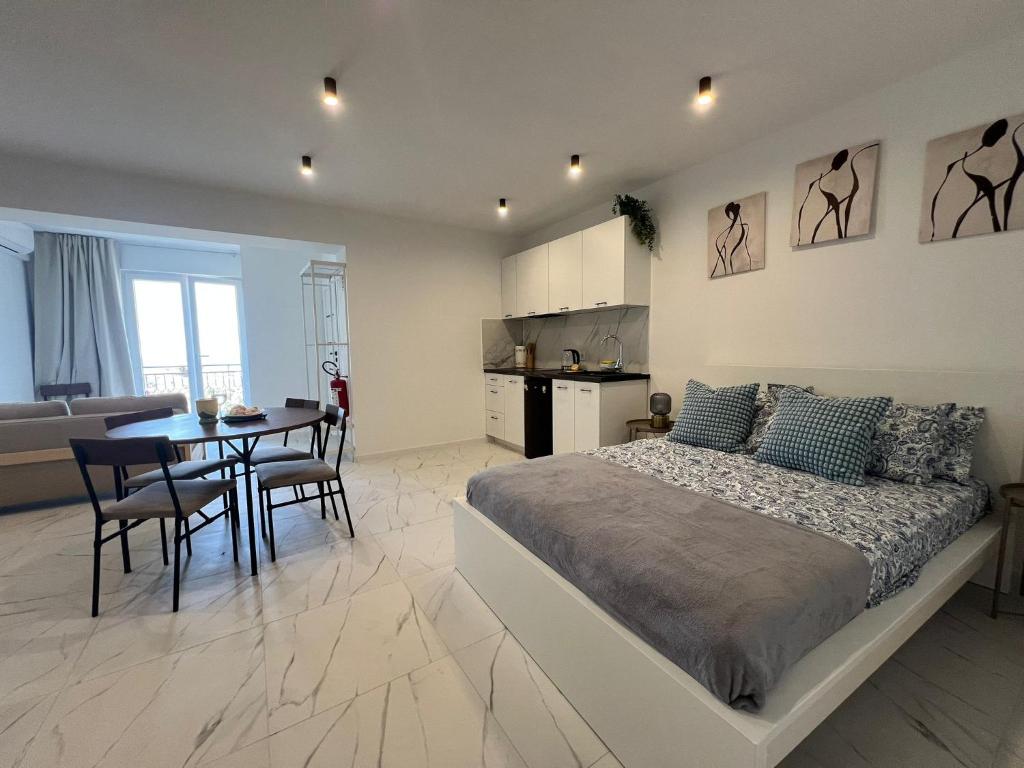 a bedroom with a bed and a table and a kitchen at Marta in Carini