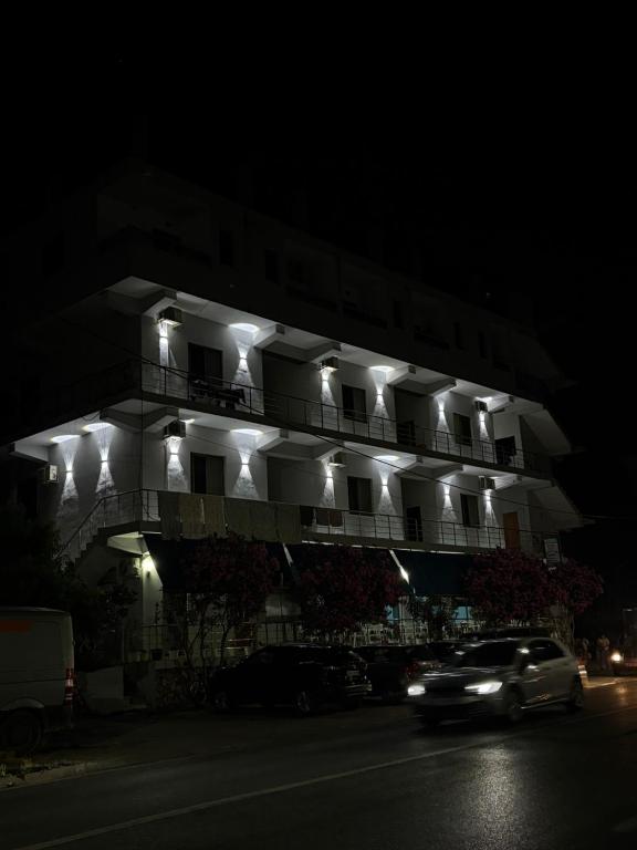 a car driving past a building with lights on it at Hotel-Bar-Riviera in Lezhë