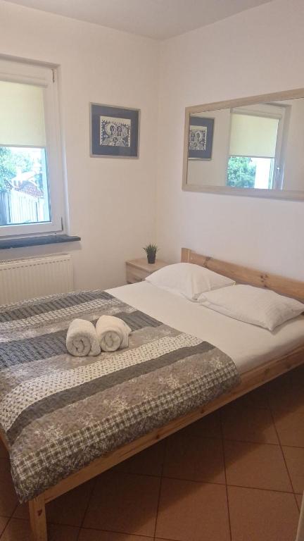 a bedroom with a bed with two towels on it at Hostel pod Modrzewiem in Świnoujście