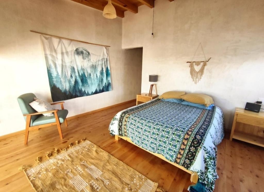 a bedroom with a bed and a chair in a room at Casa Colibri San Cristobal in San Cristóbal de Las Casas