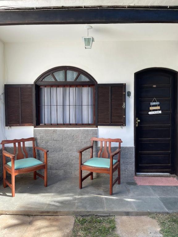 two benches sitting in front of a building at Apartmento102 - Condomínio Brisa Mar in Cabo Frio