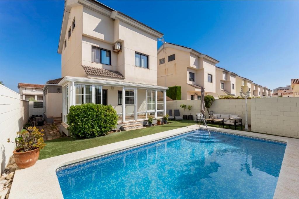 a house with a swimming pool in front of a building at Duna Blanca House - Piscina privada - 450m de la playa in Daimuz