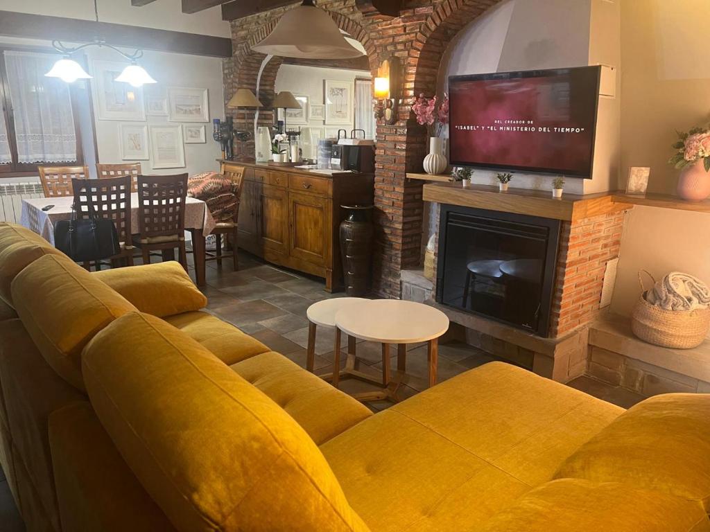 a living room with a yellow couch and a fireplace at Casa La Campa in Comillas