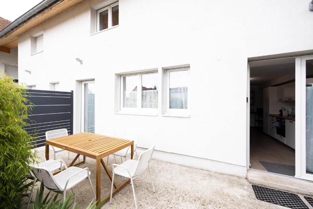a patio with a wooden table and chairs at Triple Evasion Terrasse in Zillisheim