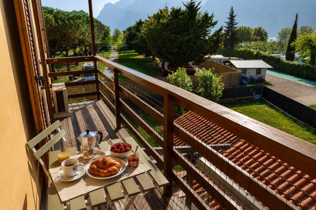 a breakfast table on a balcony with a view at Appartamento Brione Lido in Nago-Torbole