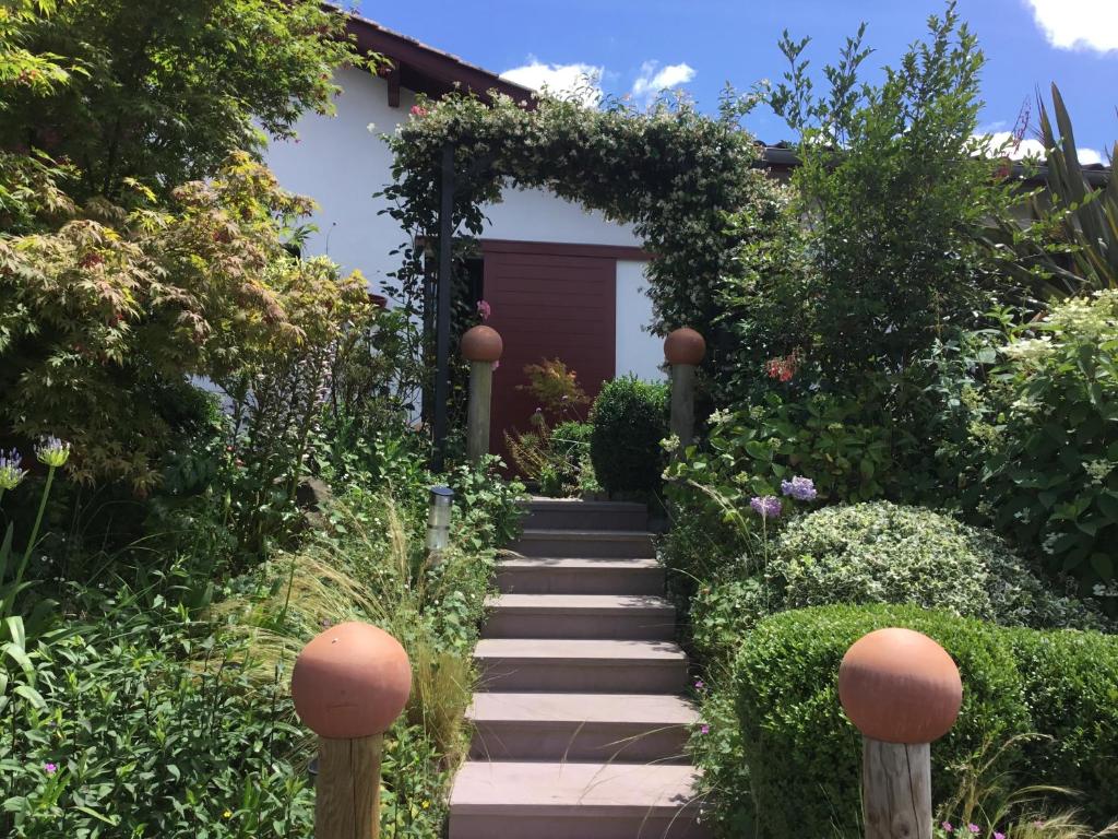 a garden with a stone path leading to a house at Maison Fleurie in Uhart-Cize