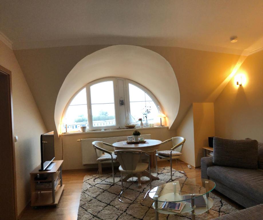 a living room with a table and a window at Hafenidyll mit Wasserblick in Karlshagen