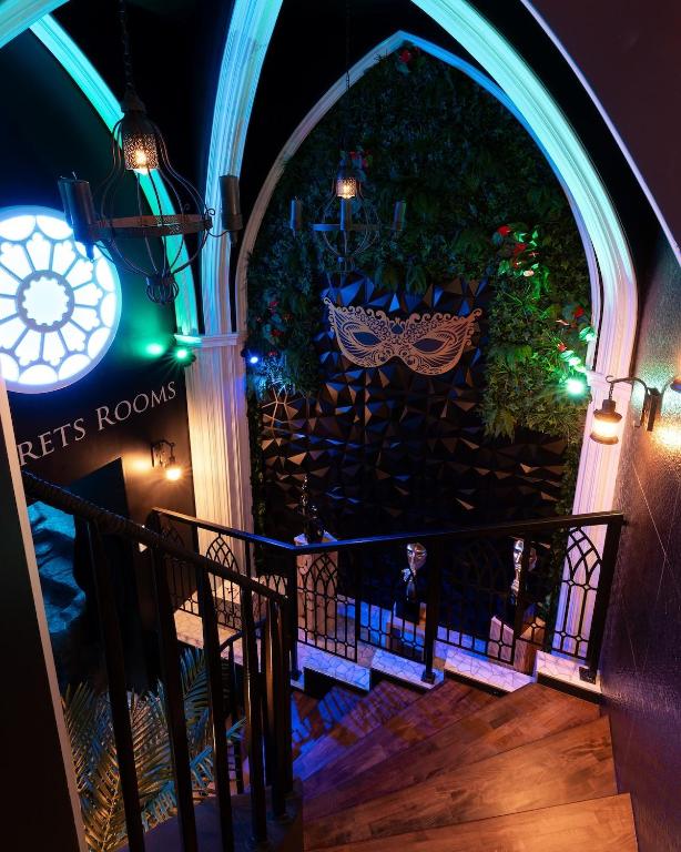 an entrance to a building with an archway and a staircase at Les Secrets Rooms - Verdun in Verdun-sur-Meuse