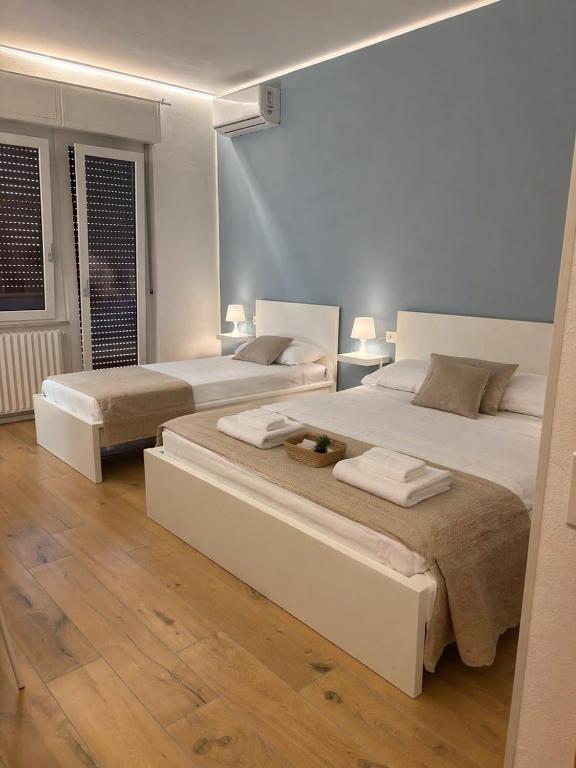 two beds in a room with wooden floors at Mary's Sweet Home in Cagliari