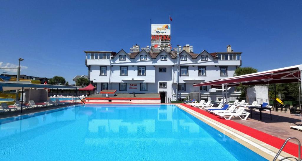 a hotel with a swimming pool in front of a building at AQUA MARMARA LİFE Hotel in Marmaraereglisi