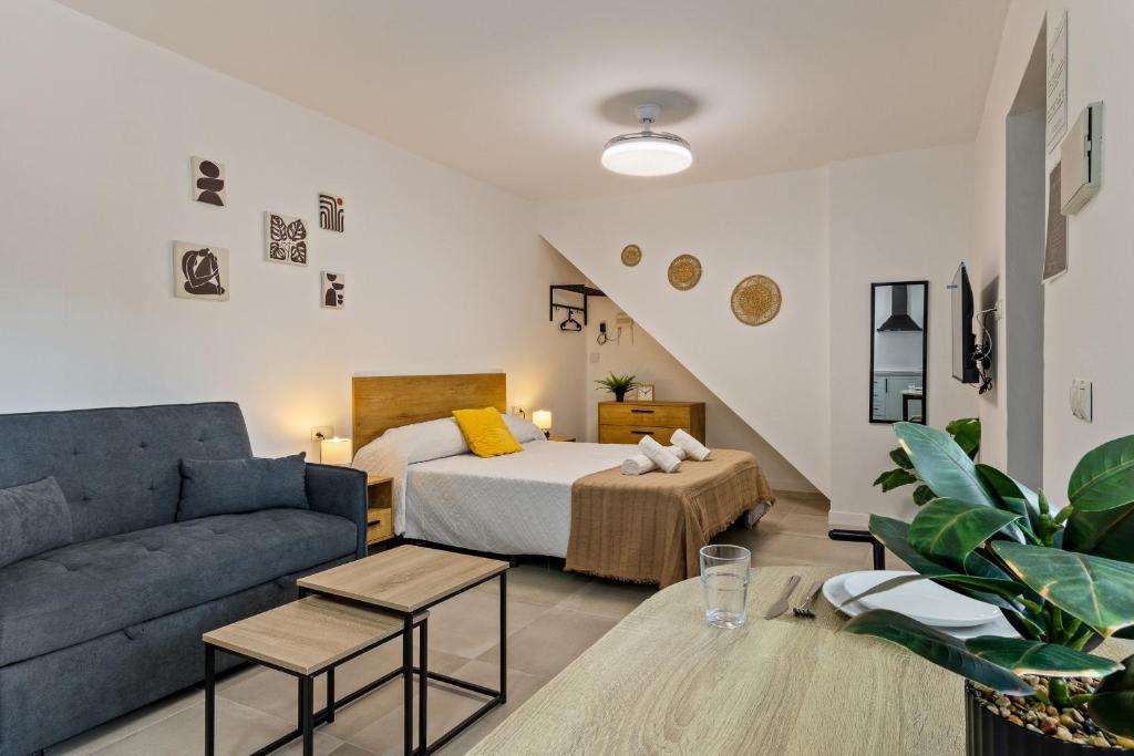a living room with a bed and a couch at Casa Los Sánchez in Alhaurín de la Torre