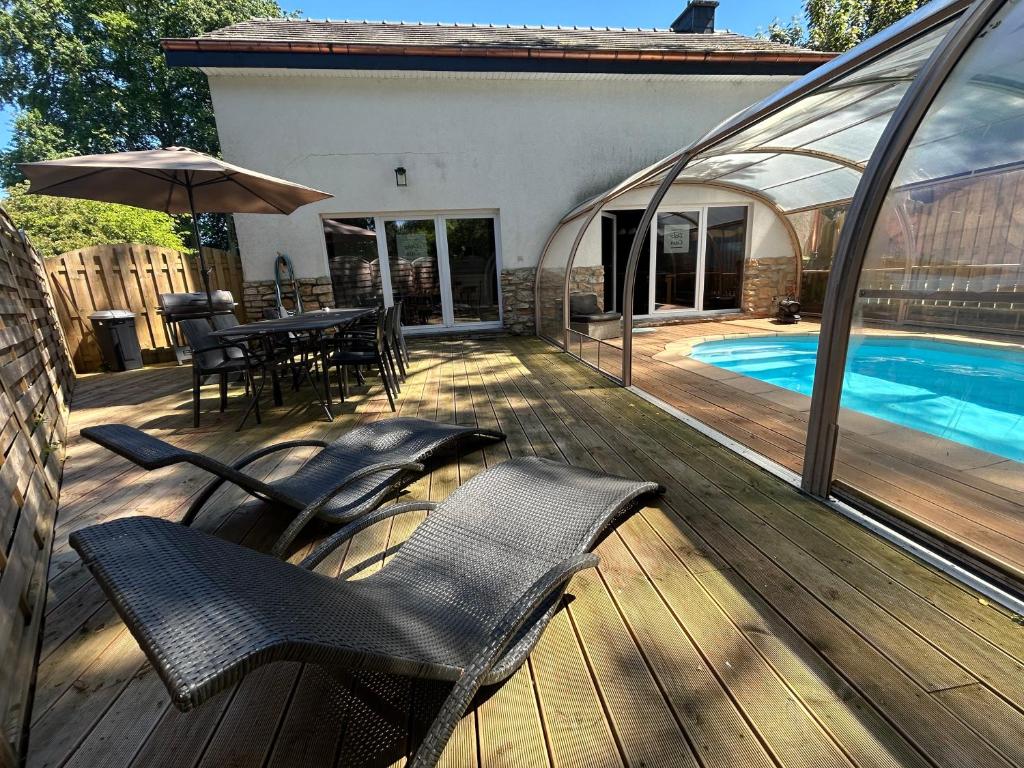 eine Terrasse mit Stühlen und einem Tisch und einem Swimmingpool in der Unterkunft Dolce Casa Pool and Sauna in Francorchamps