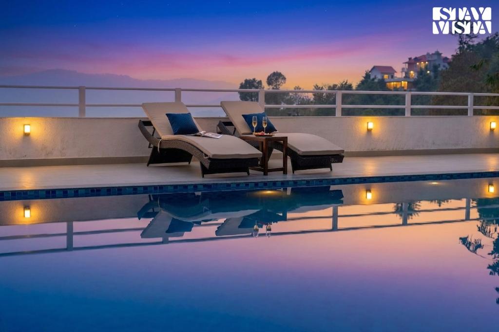 a villa with a swimming pool at night at StayVista at IRIS with Outdoor Pool & Bonfire in Dagshai