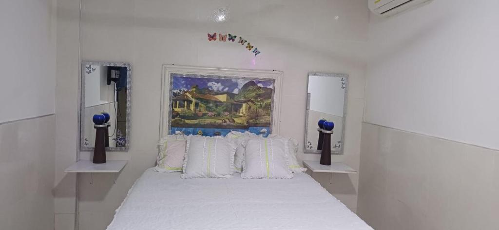 a white bedroom with a large bed with white pillows at Casa SAYBER DON DIEGO in Don Diego