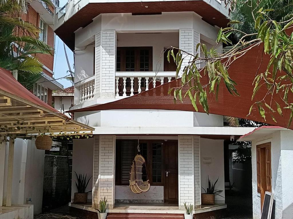 a white house with a balcony with plants at The cliff boutique in Varkala
