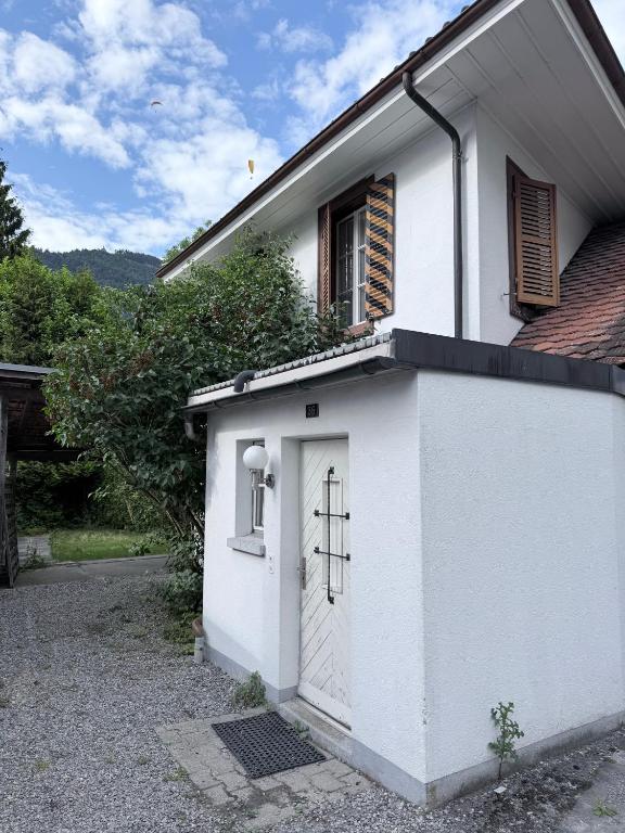a white building with a door and a window at Garden House Interlaken in Interlaken