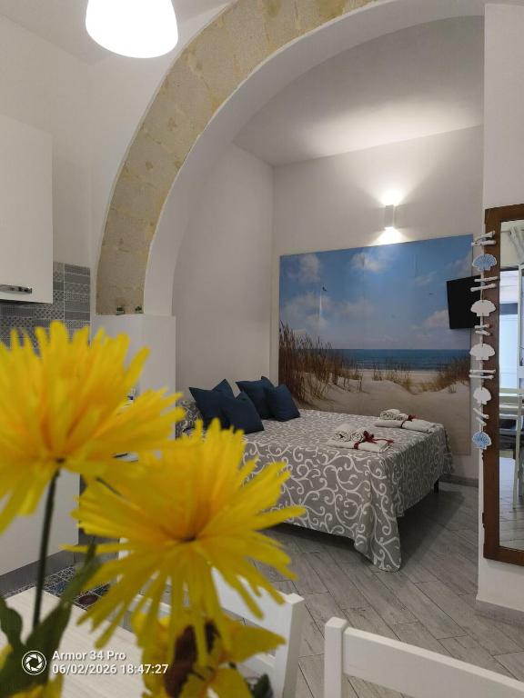 a bedroom with a bed with yellow flowers in the foreground at A Petrazzi in Castellammare del Golfo