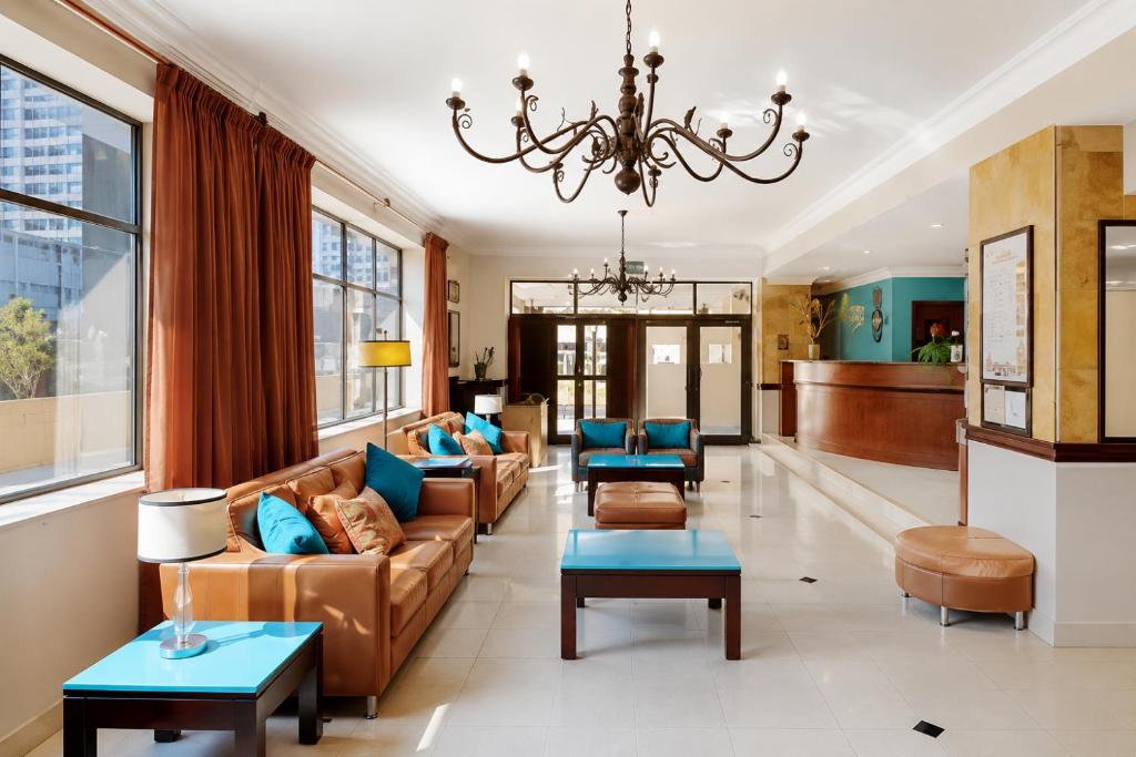 a large living room with couches and a chandelier at Oceanic 2 Bedroom Apartment - Ocean and Park View - Self-Catering in Durban