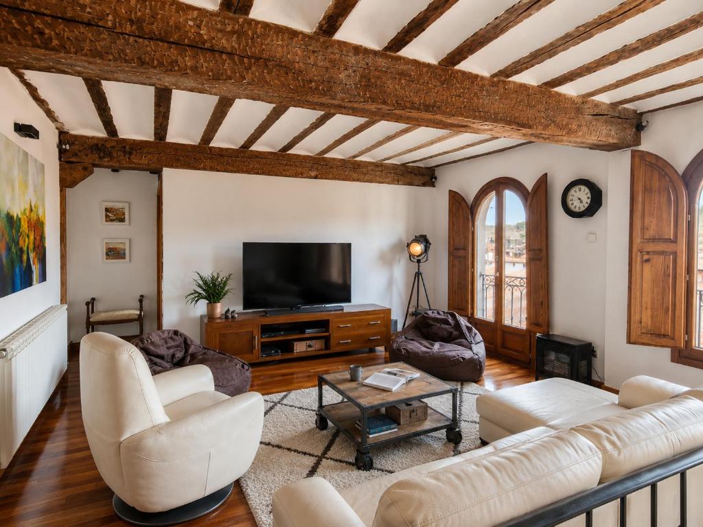 a living room with white furniture and a flat screen tv at El Palacito de Villoslada in Villoslada de Cameros