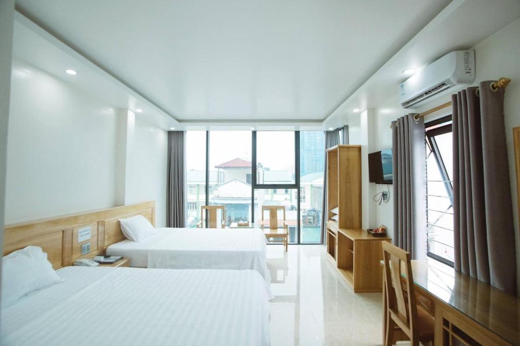 a hotel room with two beds and a large window at Tân Trang in Ha Long