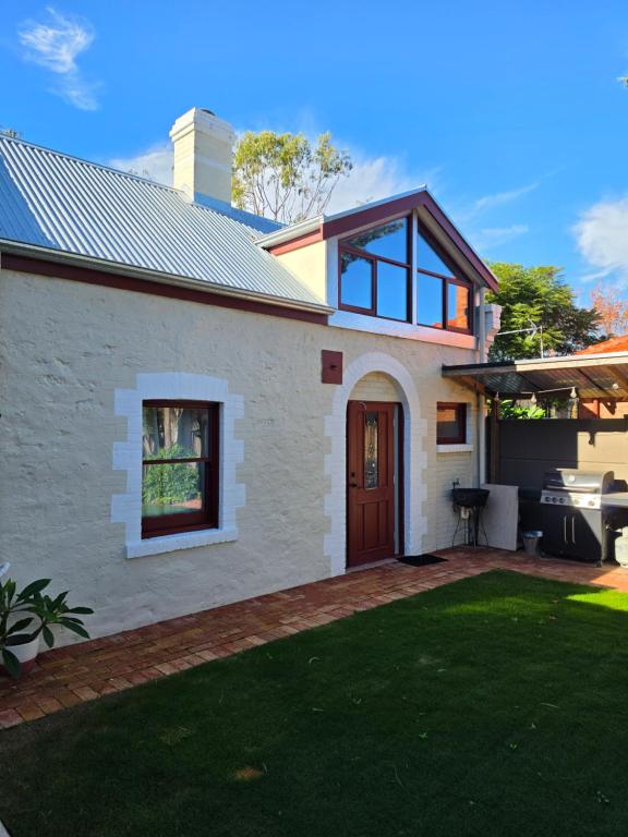 a house with a patio and a lawn at 1860 Heritage Beachside Studio in Somerton Park