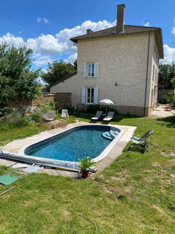 a swimming pool in front of a house at Le Clos 1003 in Saint-Didier-sur-Chalaronne