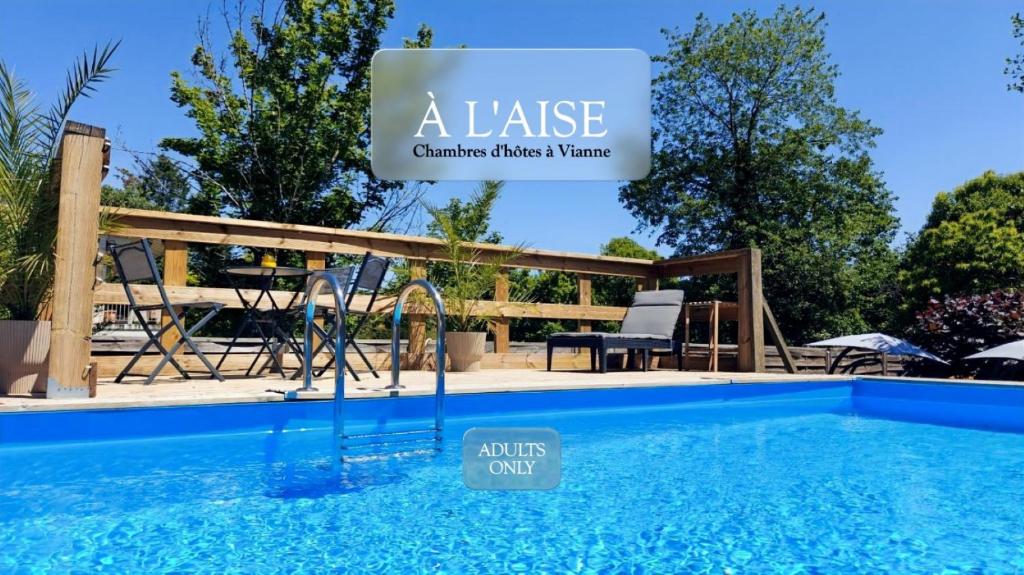 a villa with a pool and a sign that reads a lease at À L'AISE - Chambres d'hôtes à Vianne in Vianne