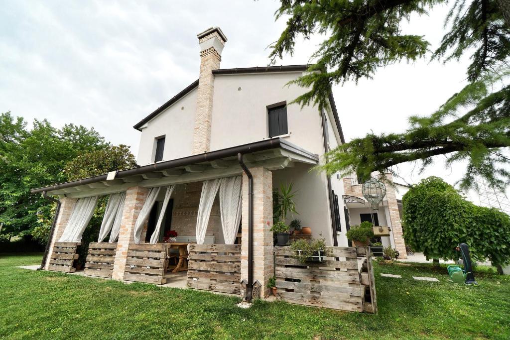 a white house with a fence in the yard at Bed and Breakfast Al Vecio Morer in San Donà di Piave