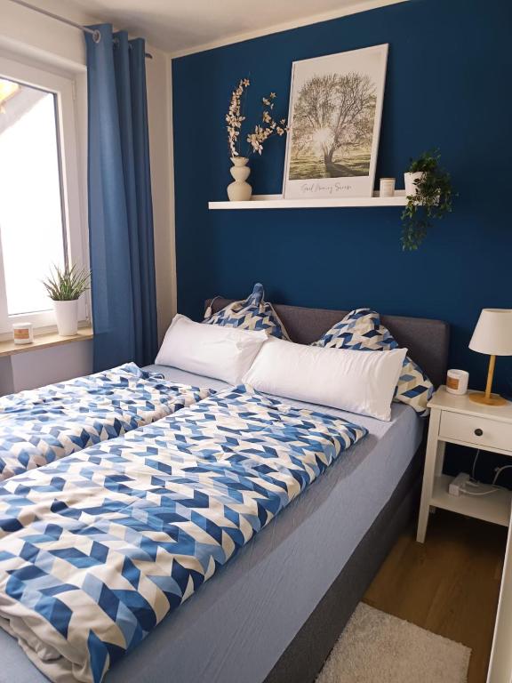 a bed in a room with a blue wall at Ferienwohnung Luitpold 1 in Memmingen