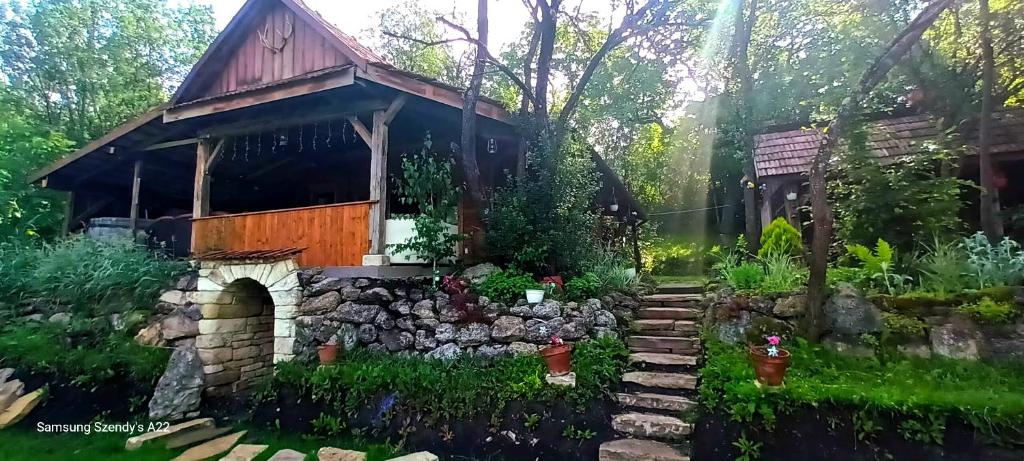 a cottage in the woods with a stone path leading up to it at Hidden Garden Kide (Chidea) in Cluj-Napoca