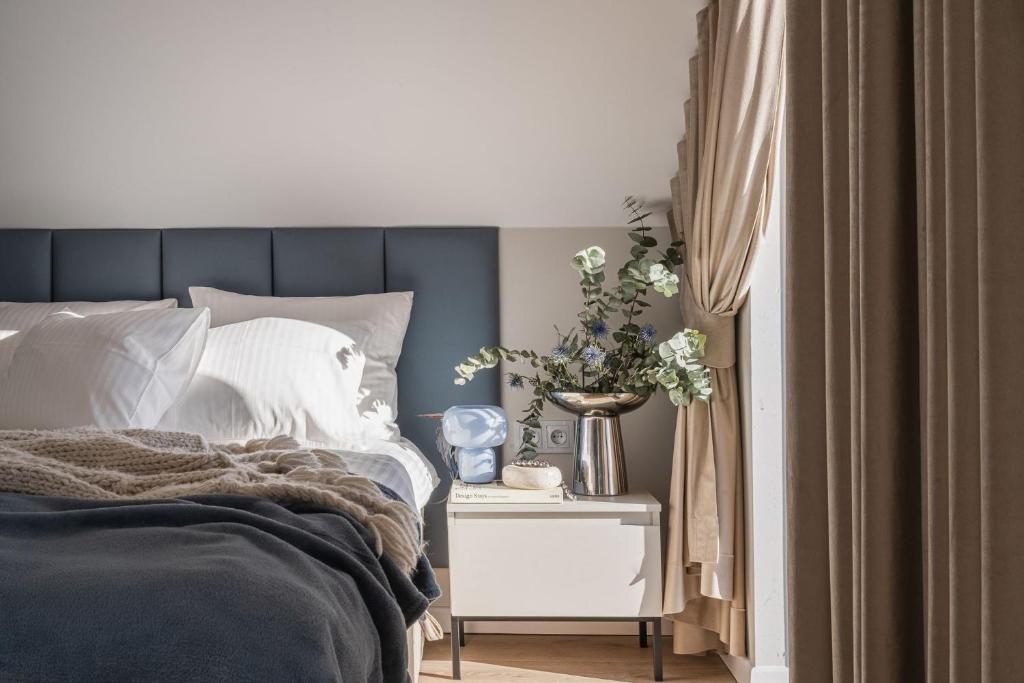 a bedroom with a bed and a side table with flowers at Osada Znamirowice in Znamirowice
