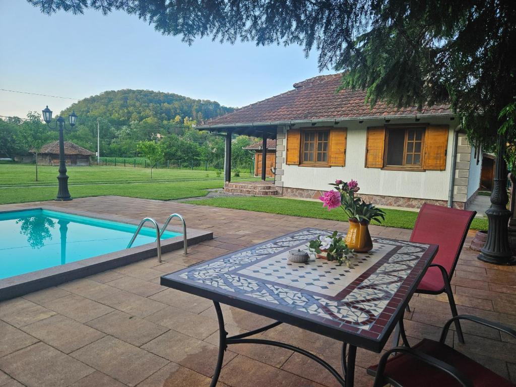 a table with flowers on it in front of a house at Zov Dičine in Savinac