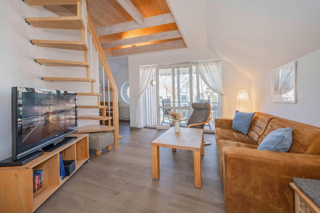 a living room with a couch and a television at Ferienanlage Seeblick Aquamarin in Koserow