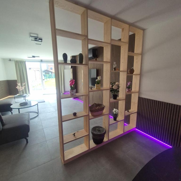 a living room with a book shelf with purple lights at House for Tomorrowland in Rijweg