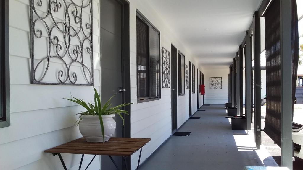 a hallway with a bench and a potted plant on it at Verandah Motel in Gympie