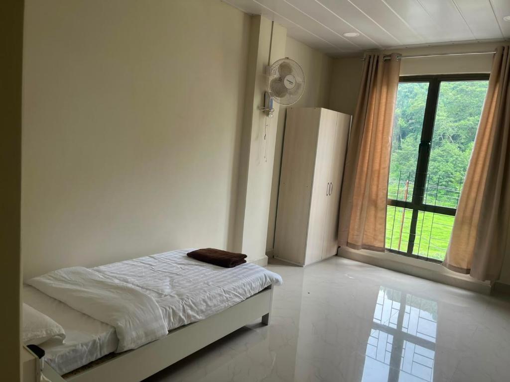 a bedroom with a bed and a large window at Hotel Paradise in Neihdawn